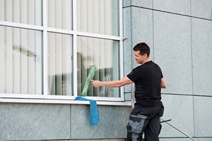 man-cleaning-ofiice-building-windows