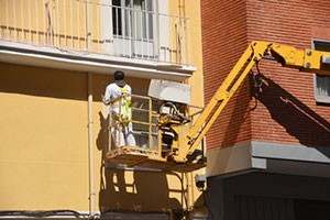 painting-apartment-block-exterior-from-raised-lift