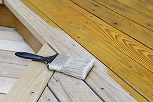 paintbrush-lying-on-partially-stained-timber-decking