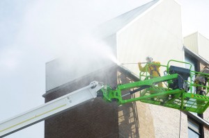 worker-on-cherry-picker-power-washing-high-industrial-building